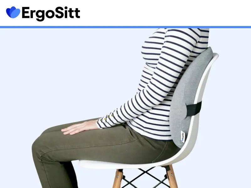 Kvinna som sitter med rak hållning tack vare ErgoSitt ländryggskudde fäst på stol