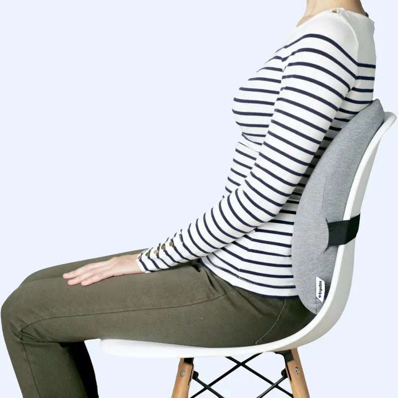 Kvinna som sitter på en matstol med ErgoStöd™ för bättre ryggstöd. Ergonomisk design för att minska smärta och förbättra hållning.