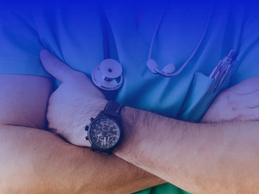 Läkare i blå uniform korsar armarna och ger tumme upp – symboliserar medicinsk expertis och godkännande, kopplat till ryggstöd och ergonomiska lösningar.