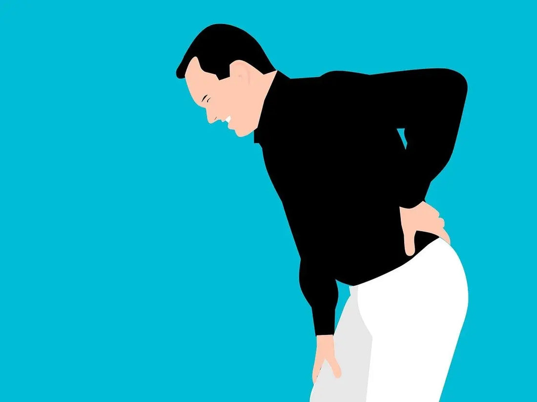 Illustration av en person som håller handen på nedre delen av ryggen, vilket indikerar smärta eller obehag i ländryggen. Personen är klädd i svart och står mot en blå bakgrund.