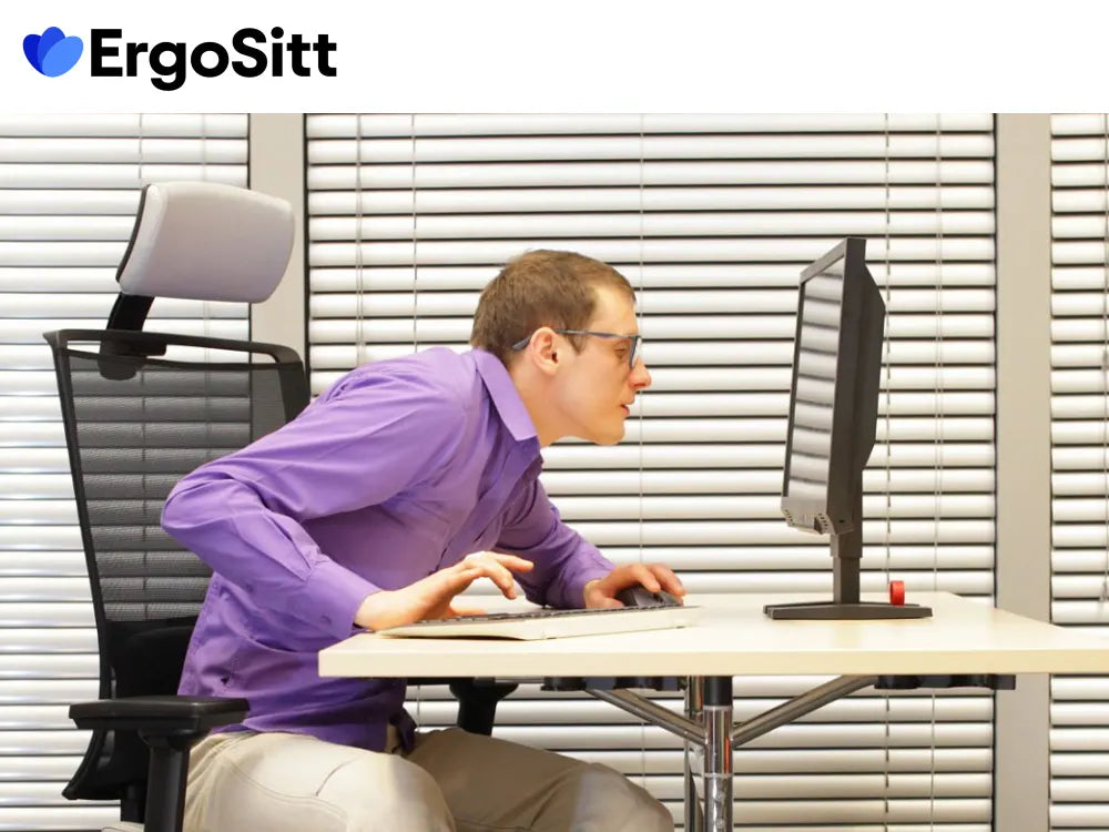 Man med dålig sittställning framför dator – vikten av rätt ergonomi
