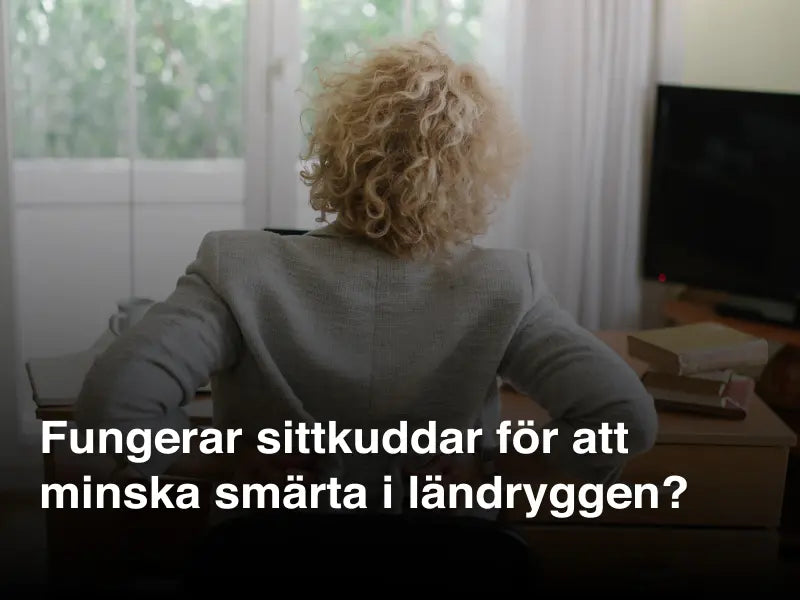 Kvinna sitter vid skrivbord och håller sig för ländryggen på grund av smärta – symboliserar behovet av ergonomisk sittkudde