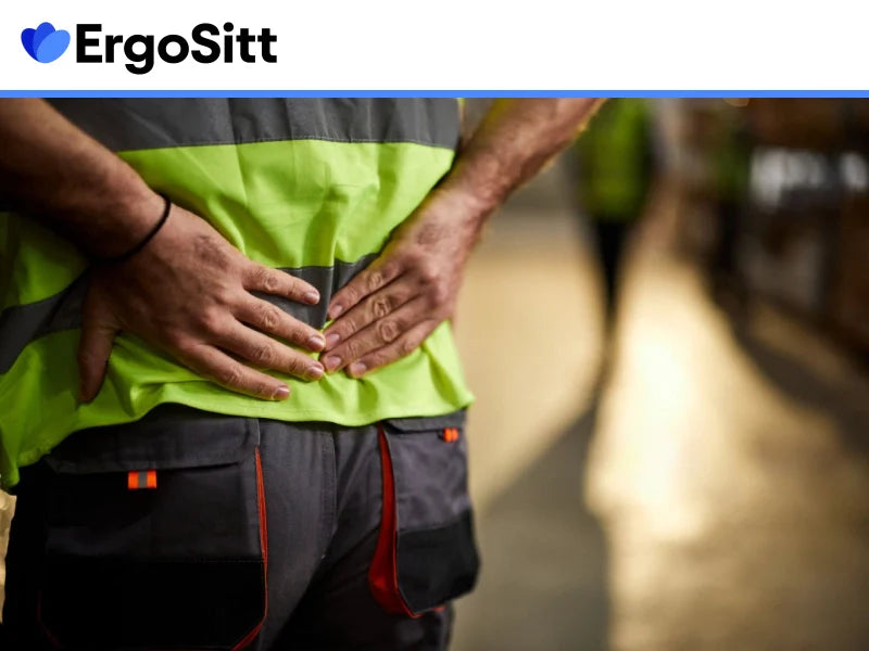 Man i arbetskläder med smärta i ländryggen efter jobbet
