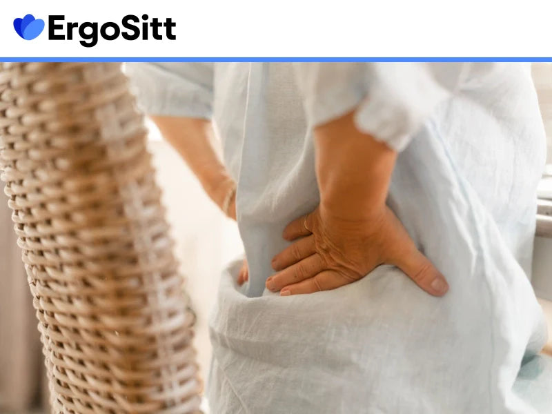 Person med ryggskott håller händerna mot ländryggen – så lindrar du akut ryggsmärta snabbt och säkert vid stillasittande