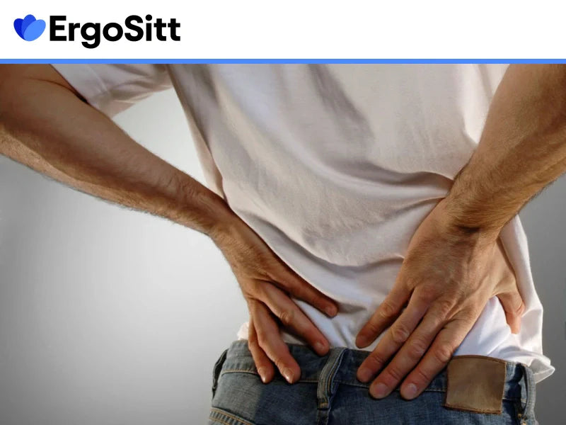 Man håller händerna mot ländryggen på grund av ryggont, behov av ergonomisk sittkudde