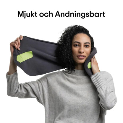 Kvinna håller upp ErgoNack ergonomisk nackkudde och visar det mjuka andningsbara materialet — lätt att linda runt nacken för bekvämt stöd