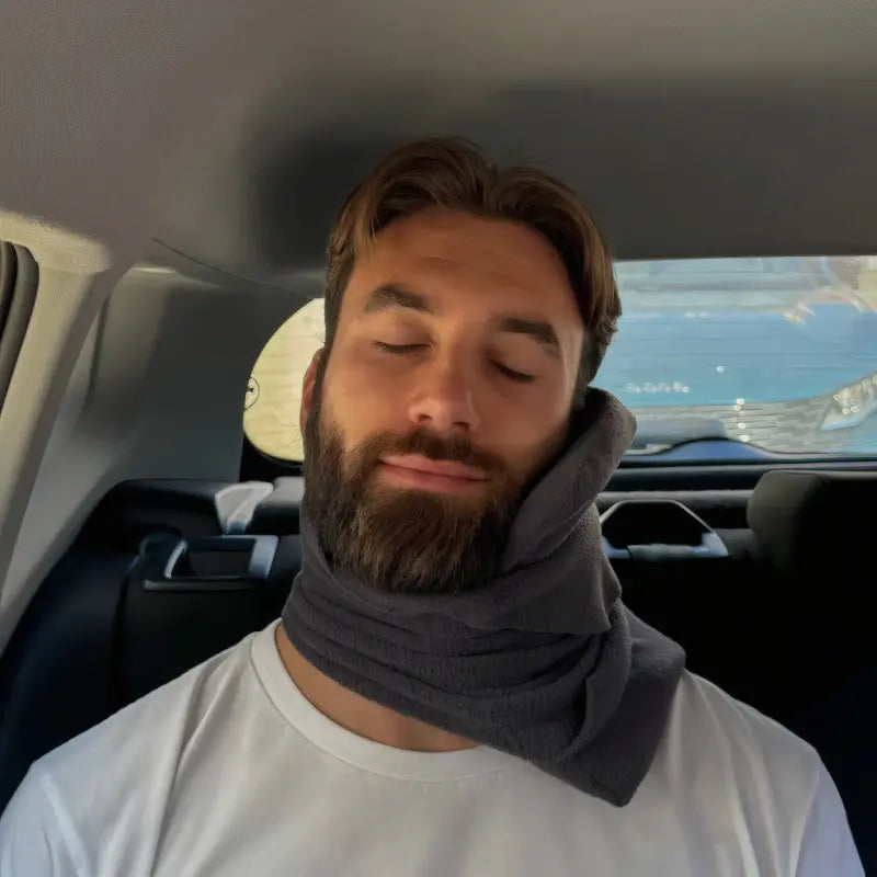 Man vilar bekvämt med ErgoNack ergonomisk nackkudde runt halsen i bilsäte — nackstöd som gör bilresan smärtfri