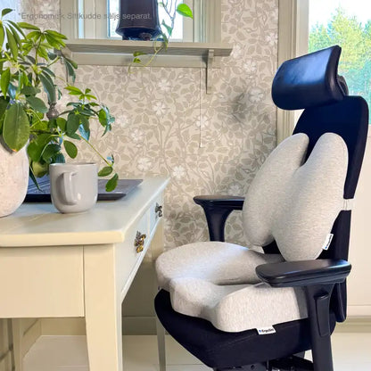 ErgoStödet ländryggskudde och ErgoKudden sittkudde placerade tillsammans på svart kontorsstol vid hemmakontor — komplett ergonomisk sittlösning för rygg och svanskota